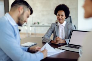 Um homem e uma mulher no Banco Bradesco falando das ações BBDC4