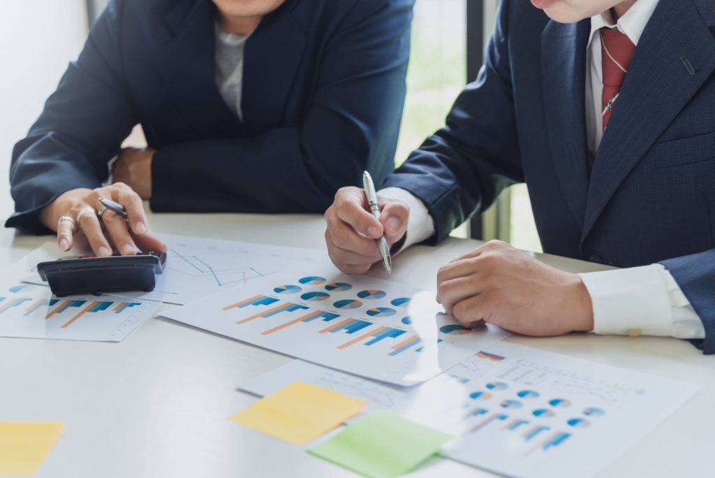 Homem e mulher analisando os indicadores financeiros estratégicos de uma empresa