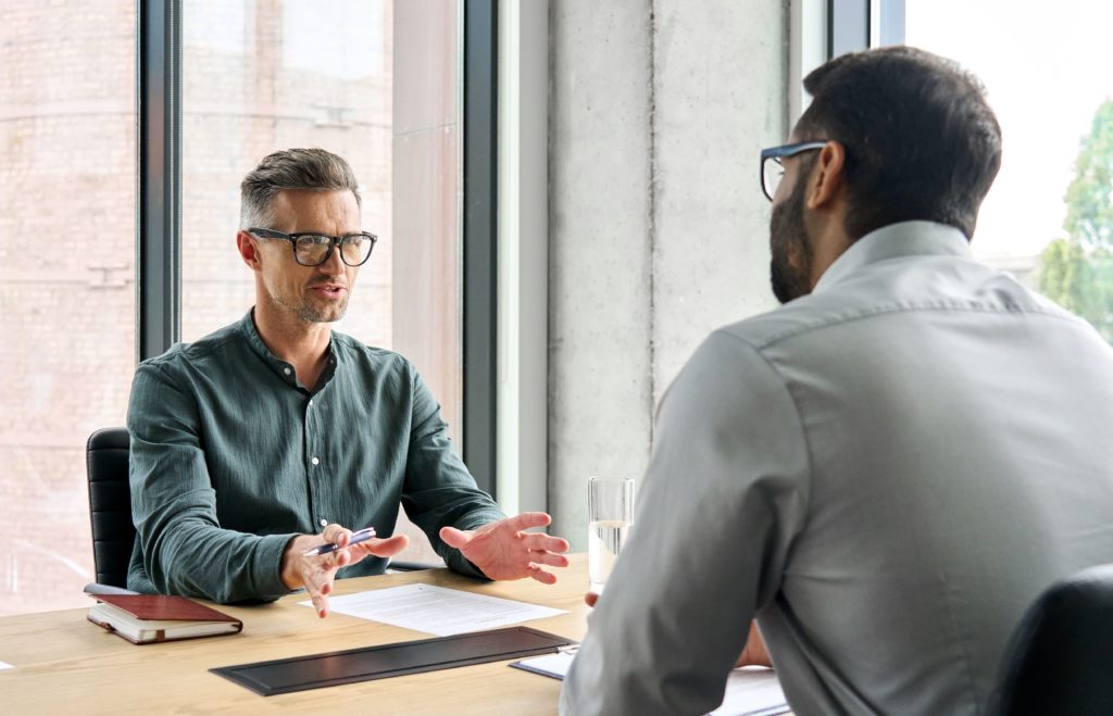 Gestor respondendo às perguntas frequentes do cliente de uma empresa de investimentos